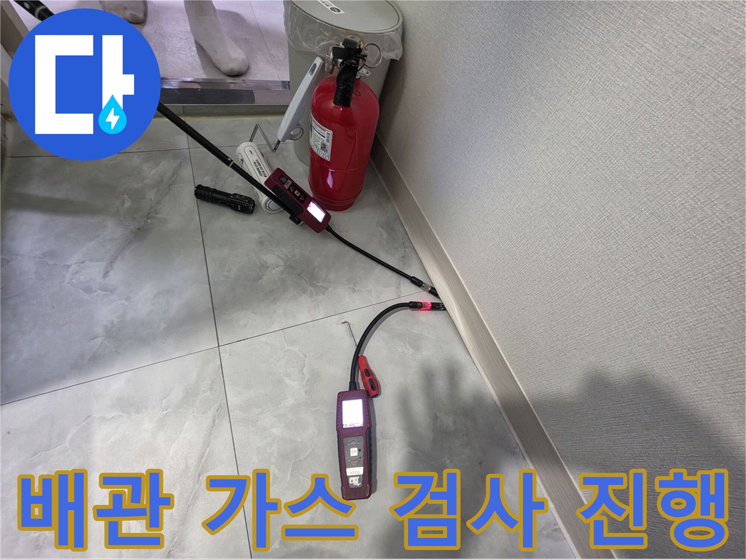 타일 바닥 위에서 작동 중인 휴대용 가스 탐지 장비와 센서 케이블