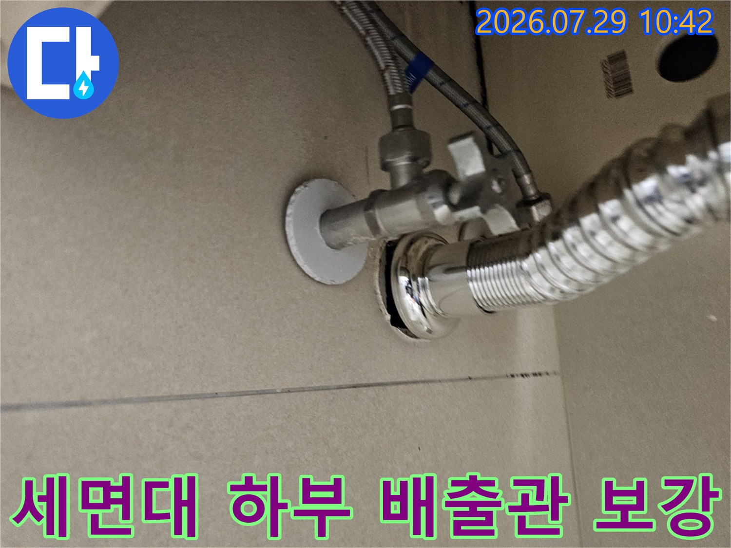 반짝이는 스테인리스 세면대 하부 배수 트랩과 연결 파이프의 상세 모습