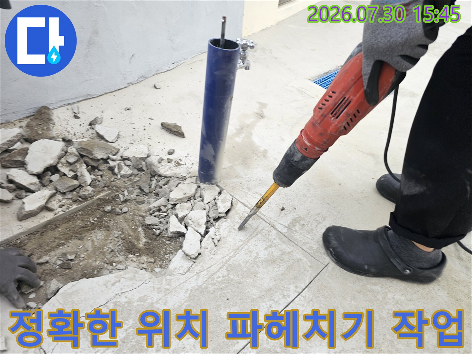 전문가용 함마드릴을 사용하여 바닥 타일과 콘크리트를 걷어내는 누수 공사 장면