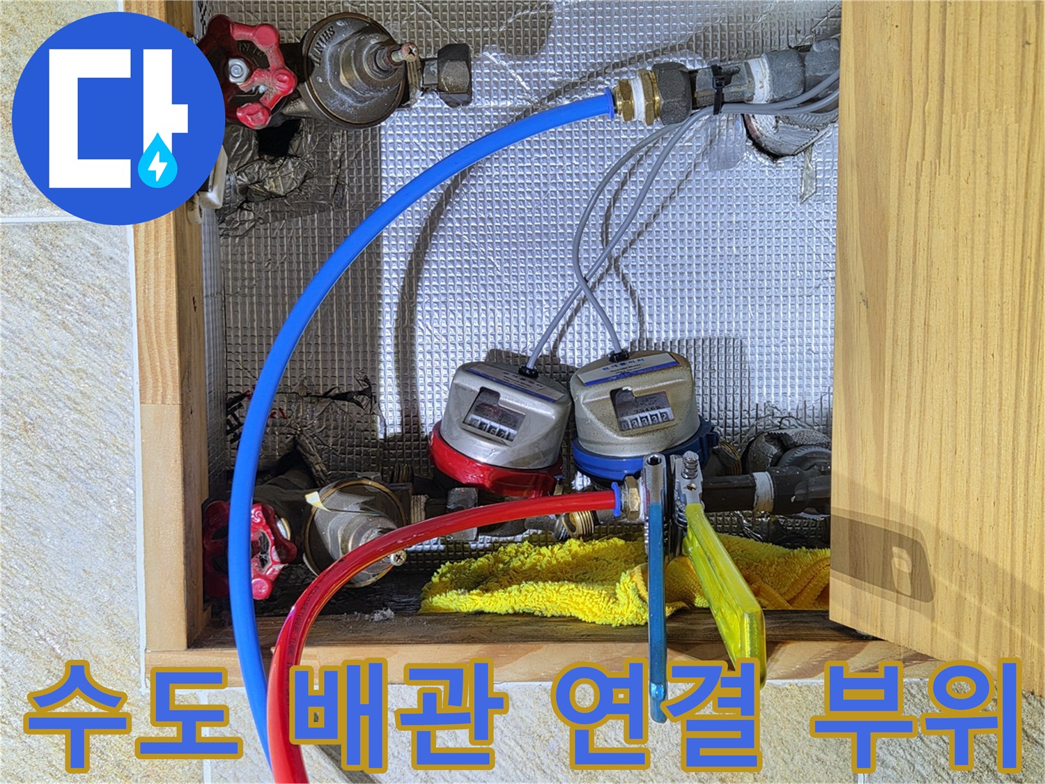 수도 계량기에 연결된 파란색과 빨验证색 급수용 배관의 상세 모습
