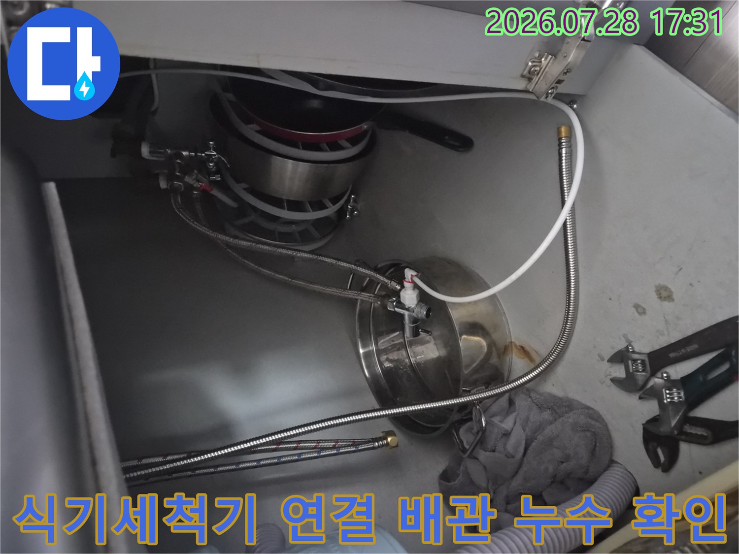 싱크대 하단부의 복잡한 수전 및 식기세척기 연결 배관 점검 사진