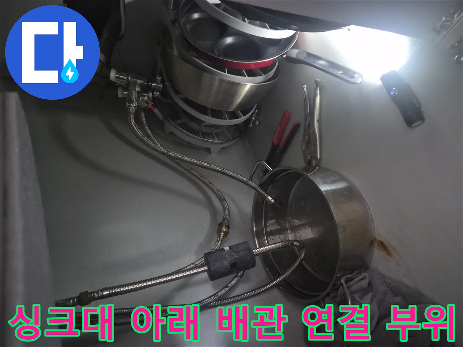 주방 하부장 내부에 설치된 식기세척기 급수용 금속 호스들