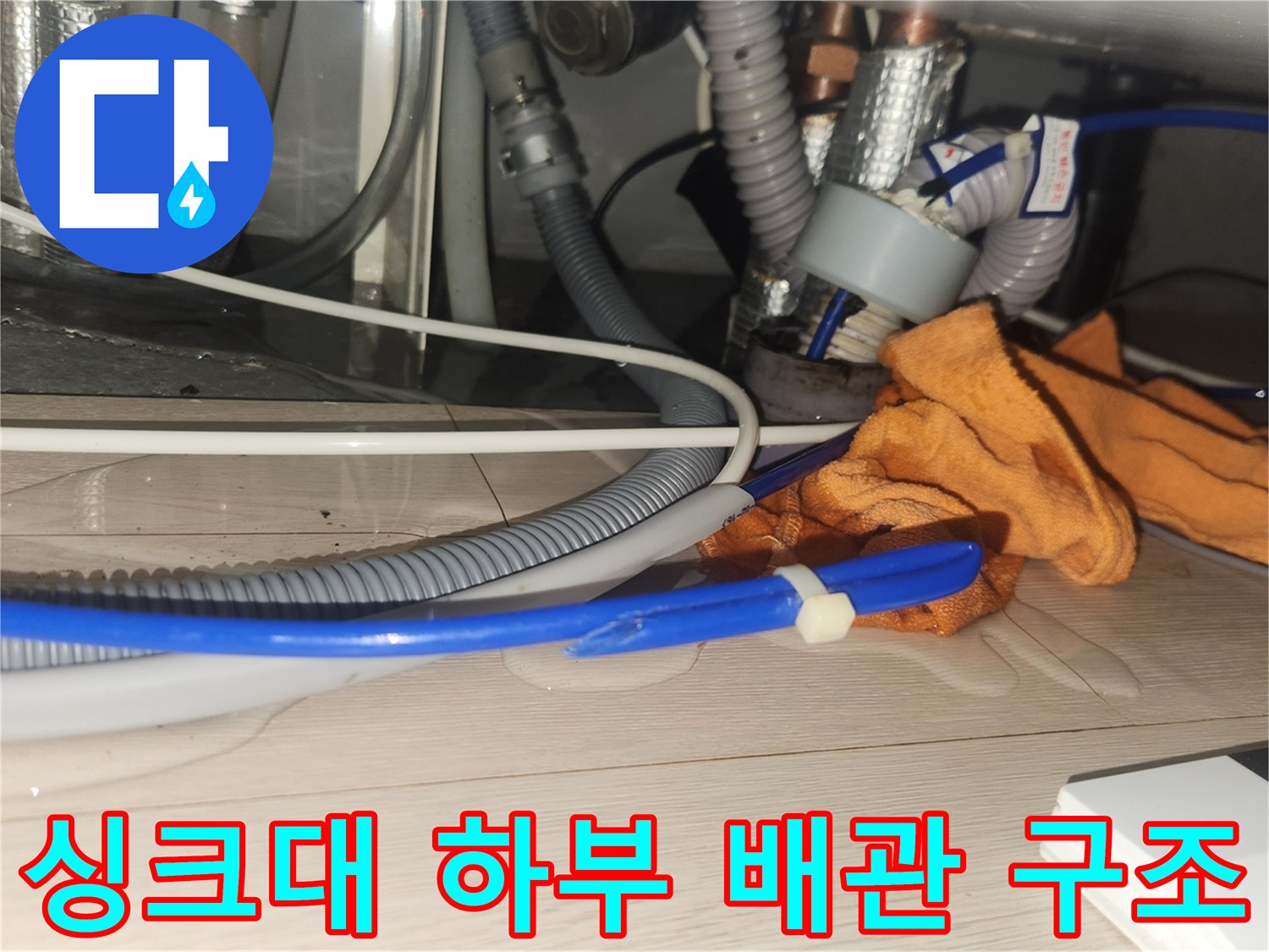 복잡하게 얽힌 싱크대 하부의 금속 및 플라스틱 배관들