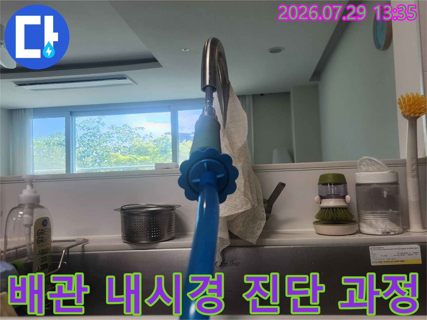 싱크대 배출구에 연결된 내시경으로 배관 내부 상황을 실시간 모니터링하는 모습