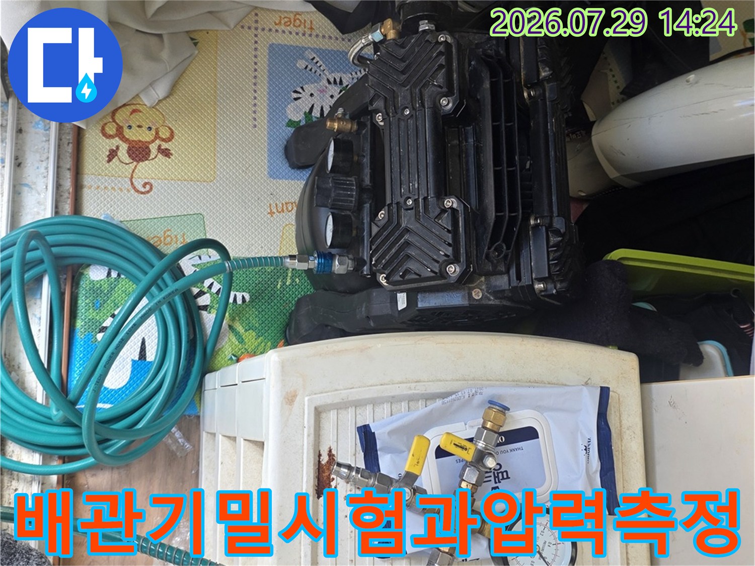 두 개의 압력 게이지와 호스를 연결하여 배관의 기밀 상태를 정밀하게 측정하는 장비 세팅