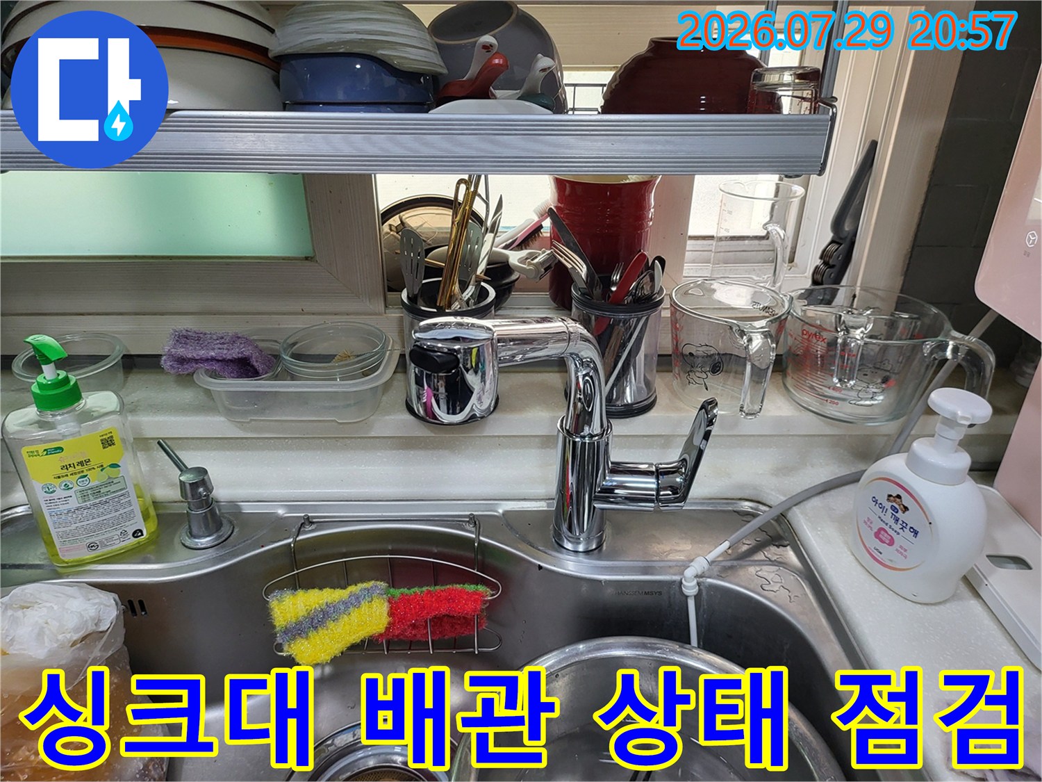 싱크대 하부의 누수 징후를 파악하기 위해 배관과 수전 부위를 세밀히 점검하는 모습입니다.