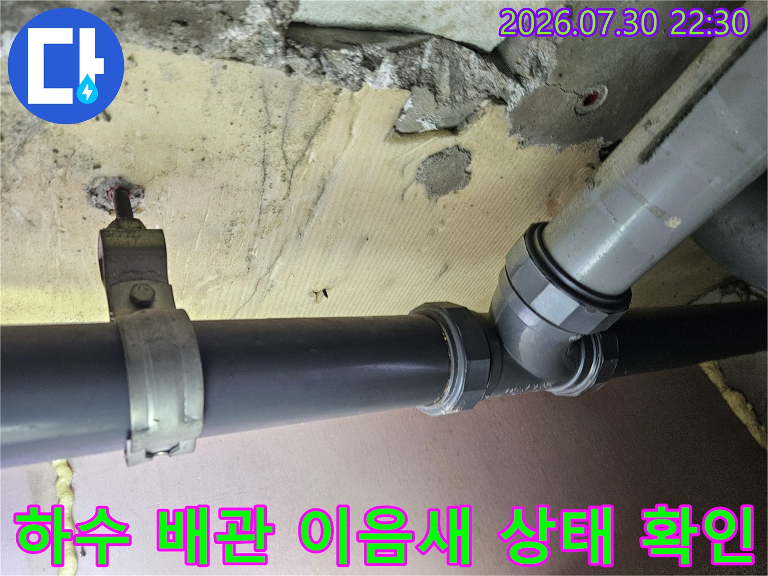 천장 내부에 노출된 하수 배관의 연결 부위를 촬영한 사진