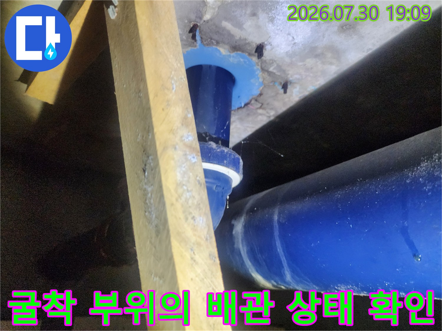 파란색으로 도색된 수직 및 수평 배관 연결부와 주변 바닥면을 정밀 점검하는 모습