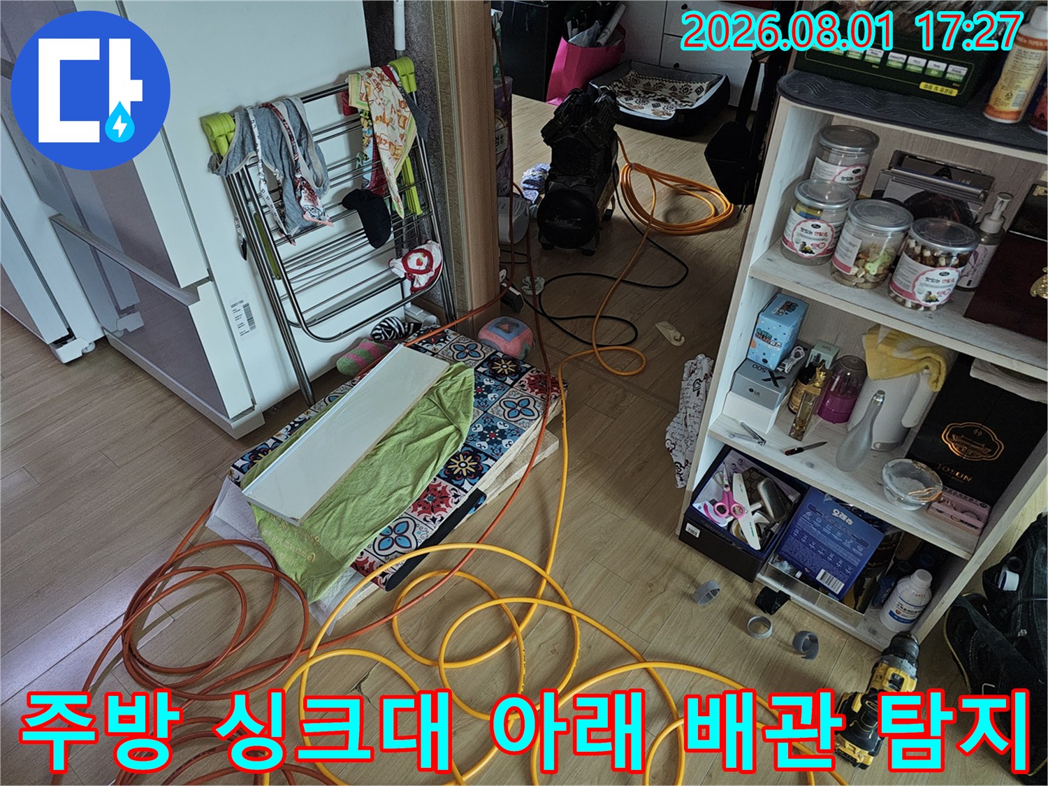 싱크대 밑을 파헤쳐 노출된 배관과 다양한 누수 점검 장비들