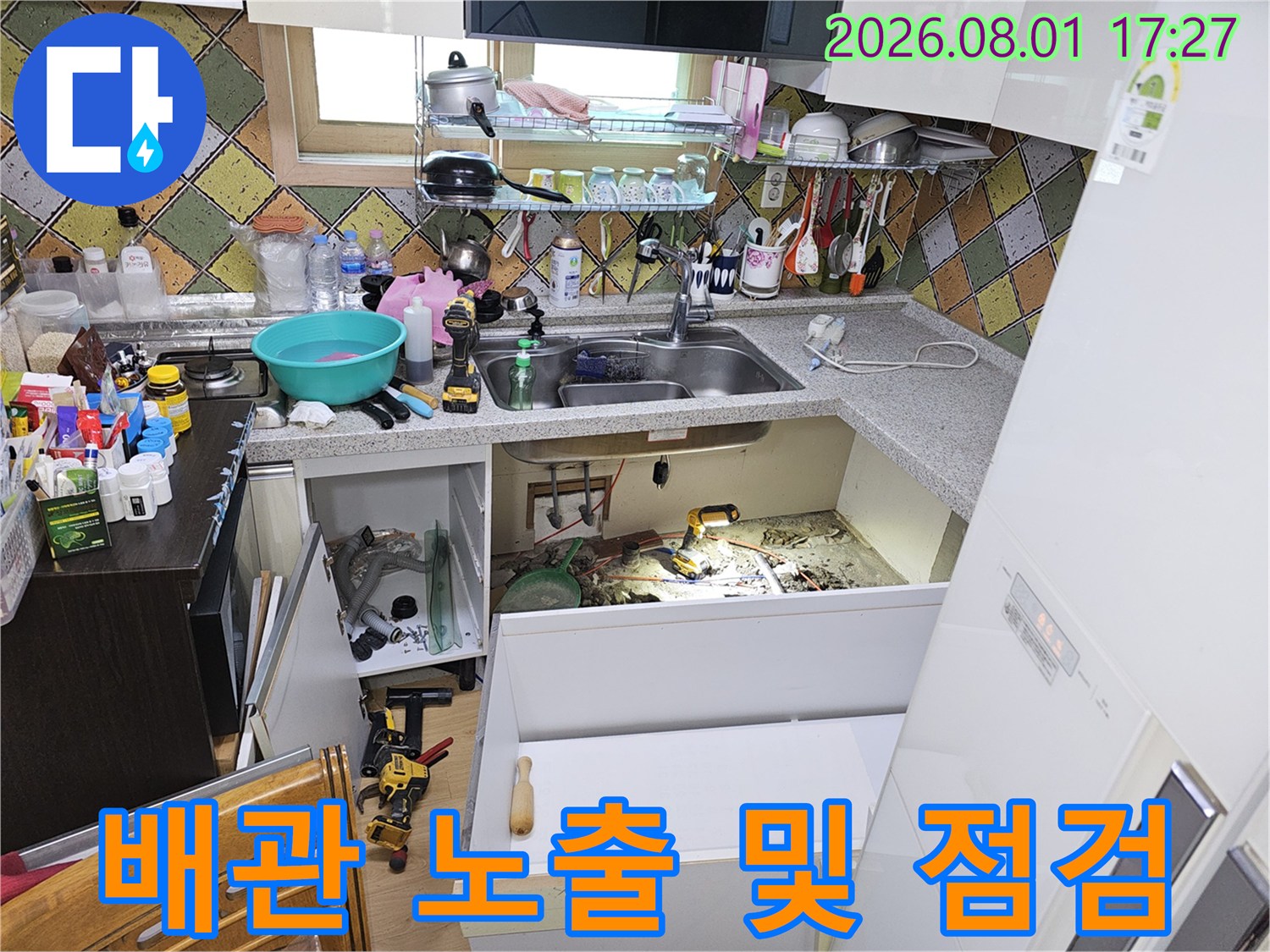 싱크대 아래 파헤쳐진 바닥과 외부로 드러난 배관 시스템
