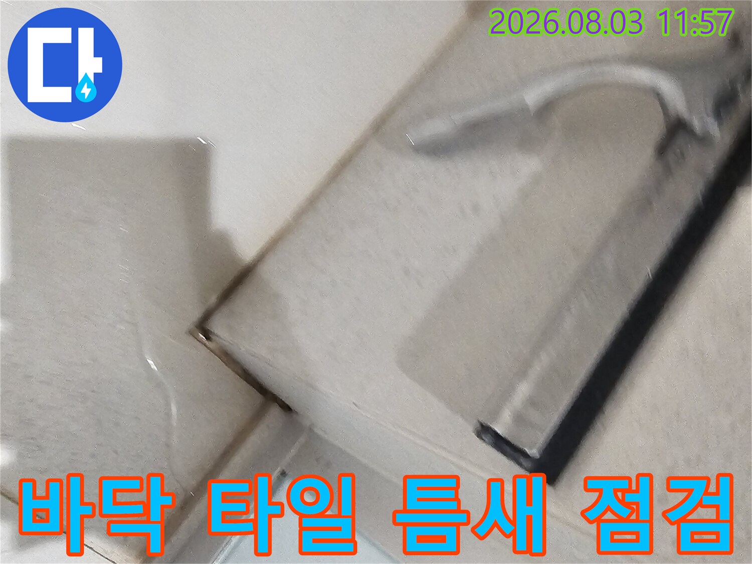 타일 사이의 미세한 균열과 배수구 주변 마감 상태를 촬영한 사진