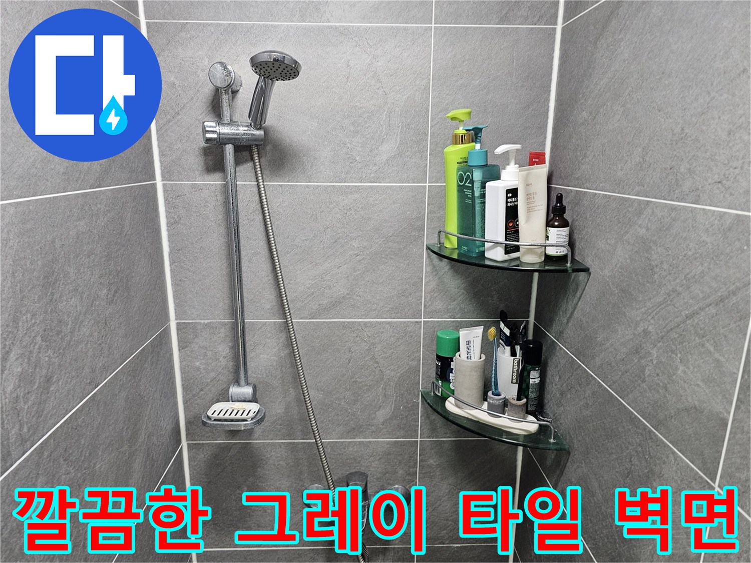 회색 욕실 타일과 샤워기 수전이 설치된 모습입니다.
