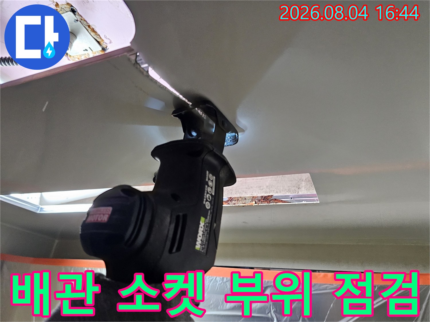 드라이버로 천장 배관의 굴곡진 연결 지점을 세세하게 살피는 전문가 작업 장면