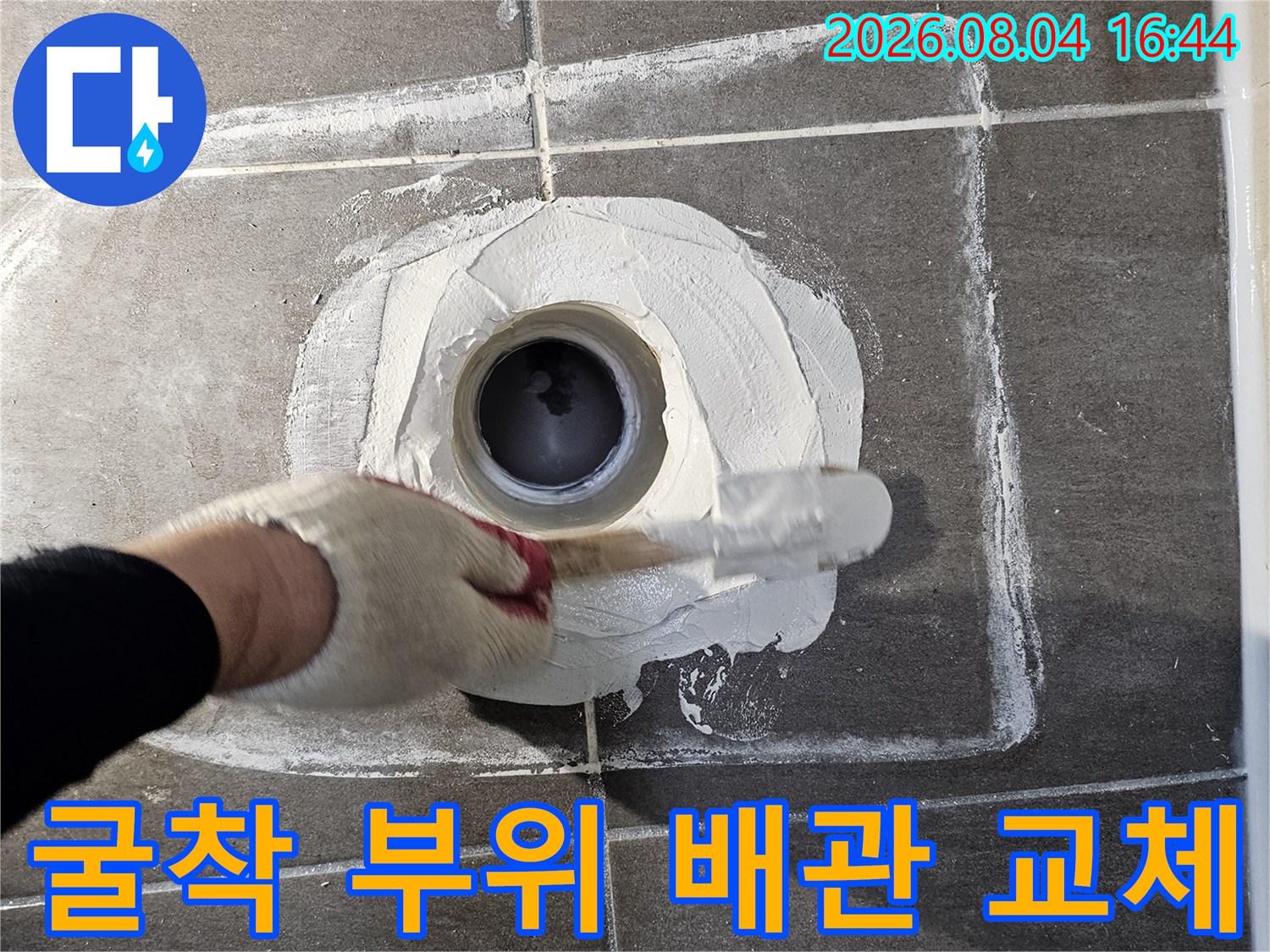 작업자가 장갑을 착용하고 노출된 배관의 소켓 부분을 수리하는 사진