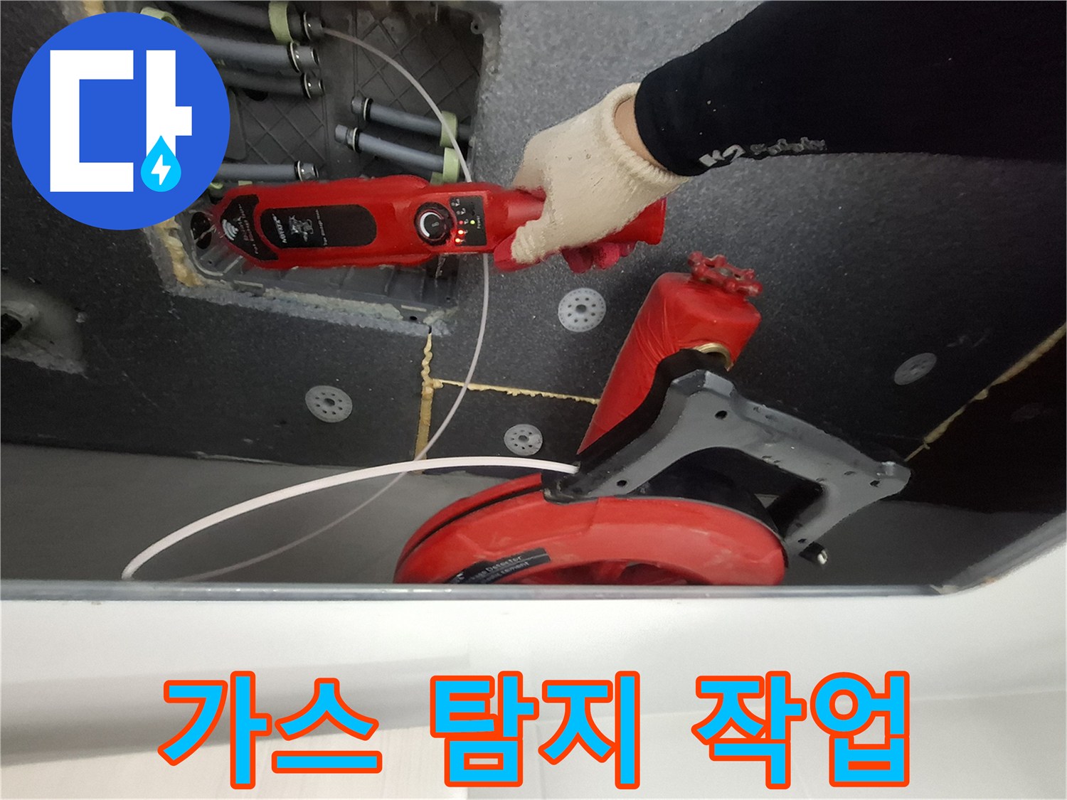 천장 배관의 누수를 찾기 위해 가스 탐지기를 사용하는 모습