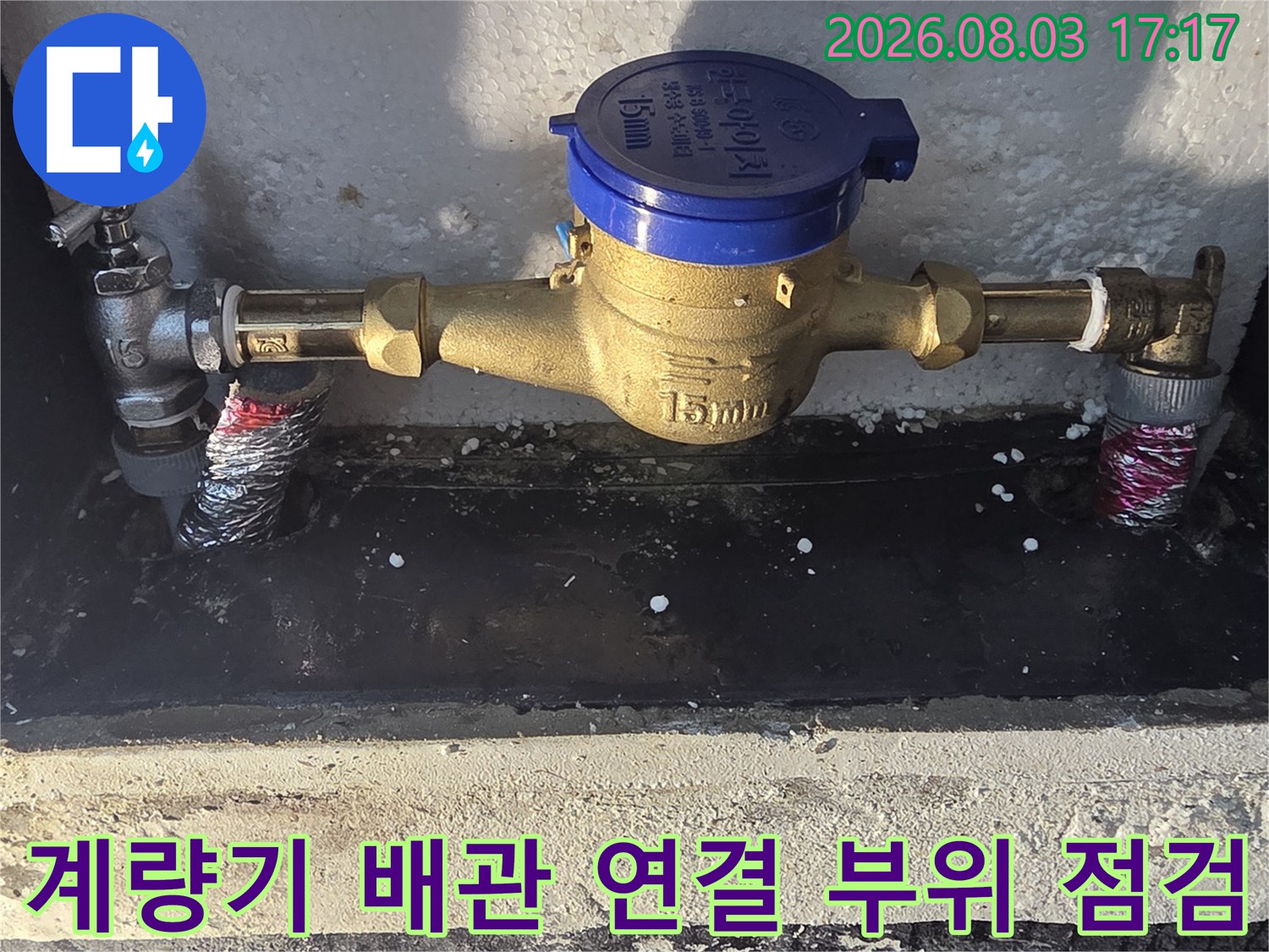 노란색 계량기와 연결된 금속 배관의 상세 모습