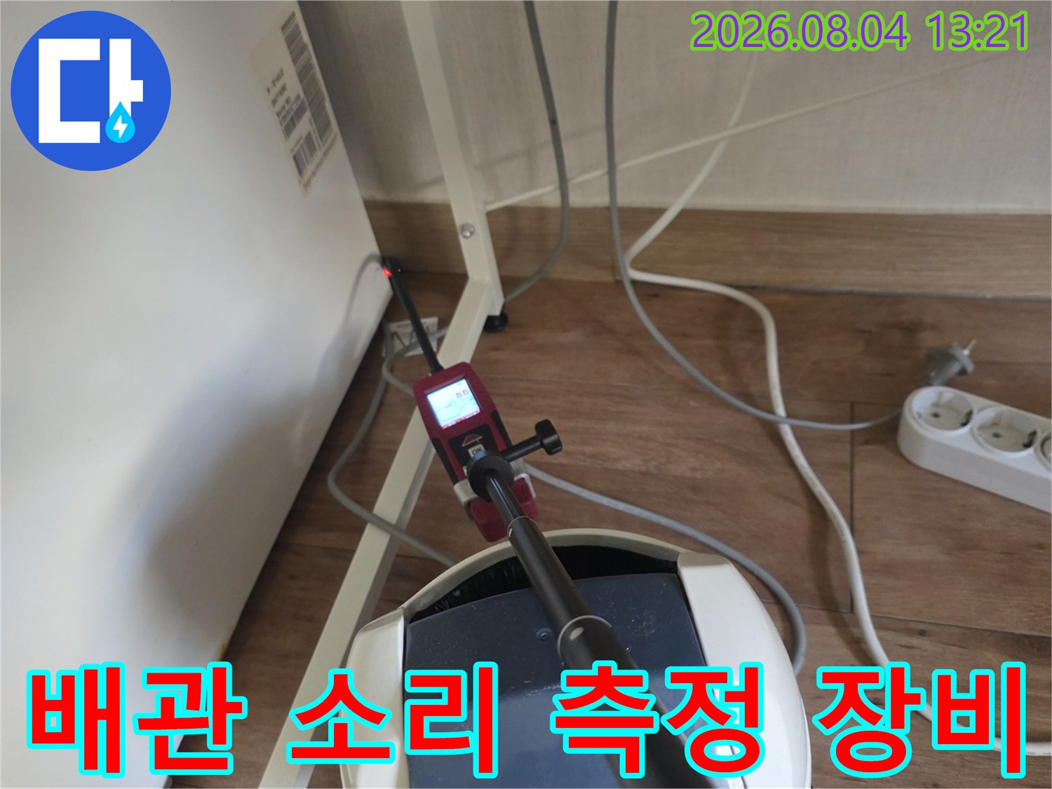 고성능 청음 탐지기를 사용하여 벽 안쪽의 온수 배관 소음을 분석하는 모습
