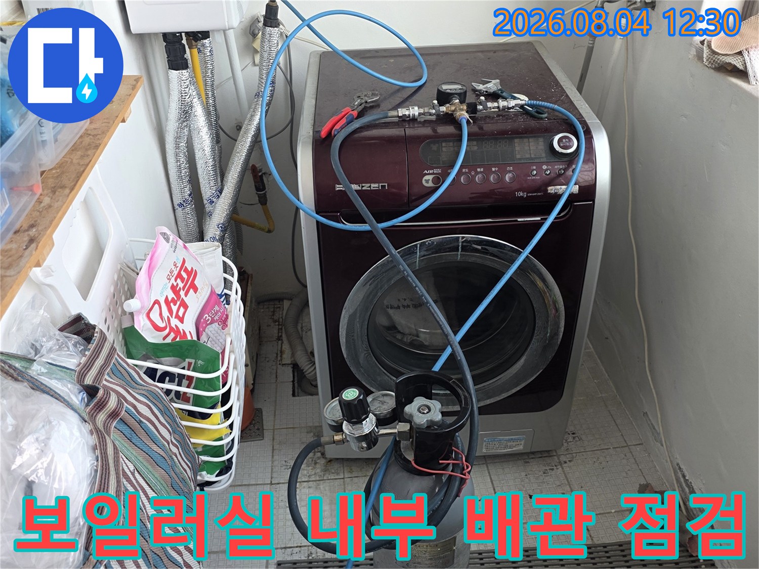 노출된 파란색 배관과 가스통이 위치한 보일러 실의 점검 장면
