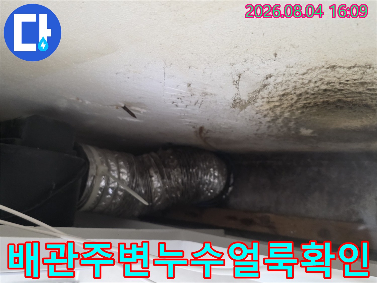 누수로 인해 오염된 천장면과 배관 노출 부위를 점검하는 모습