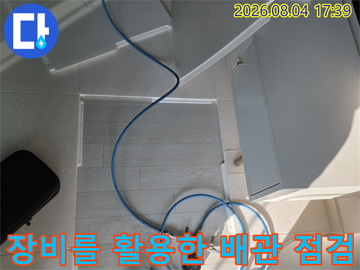 압력계와 호스를 연결하여 배수 배관의 흐름을 체크하는 장면