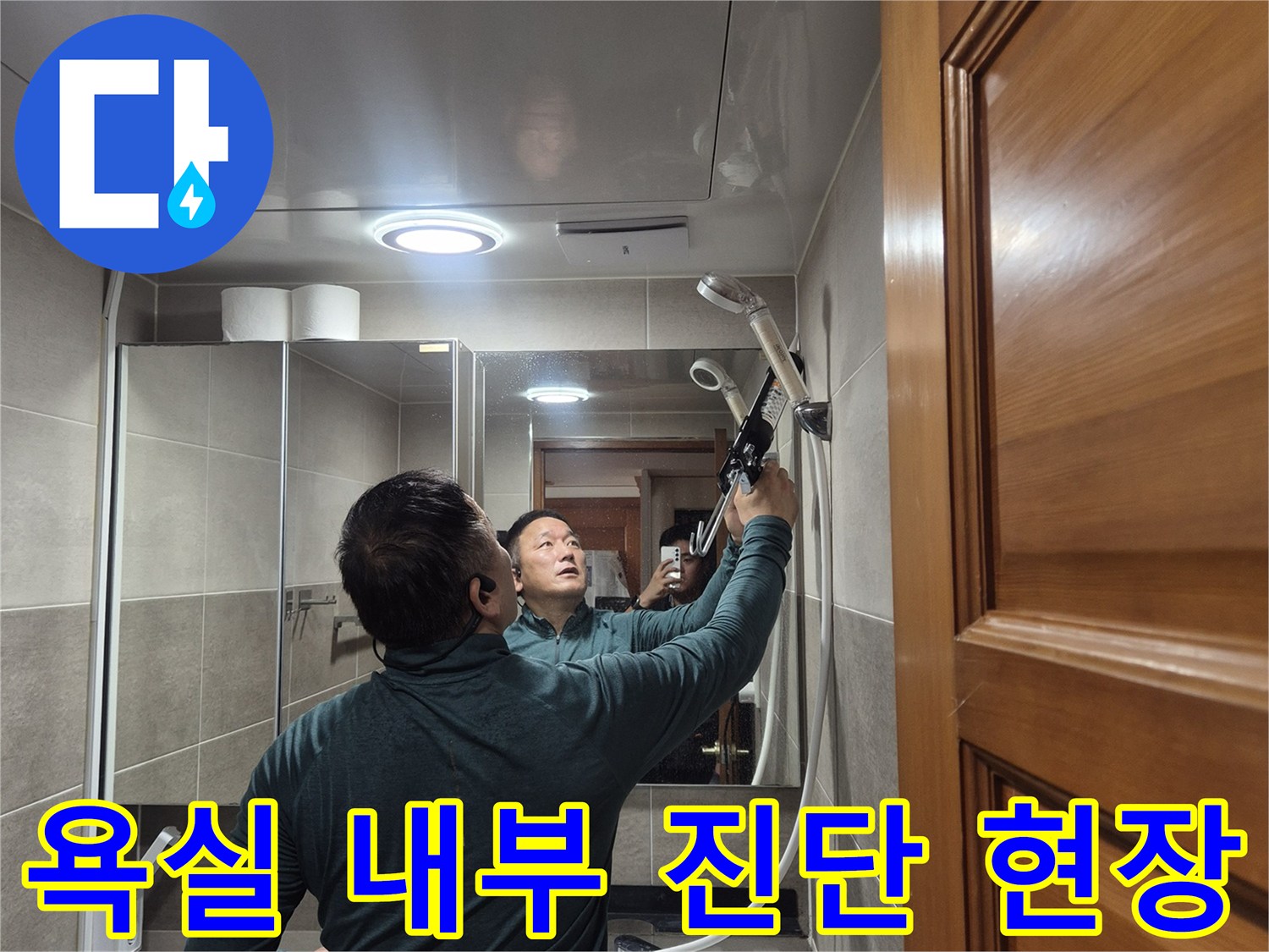거울이 있는 화장실에서 누수 부위를 찾는 엔지니어의 모습