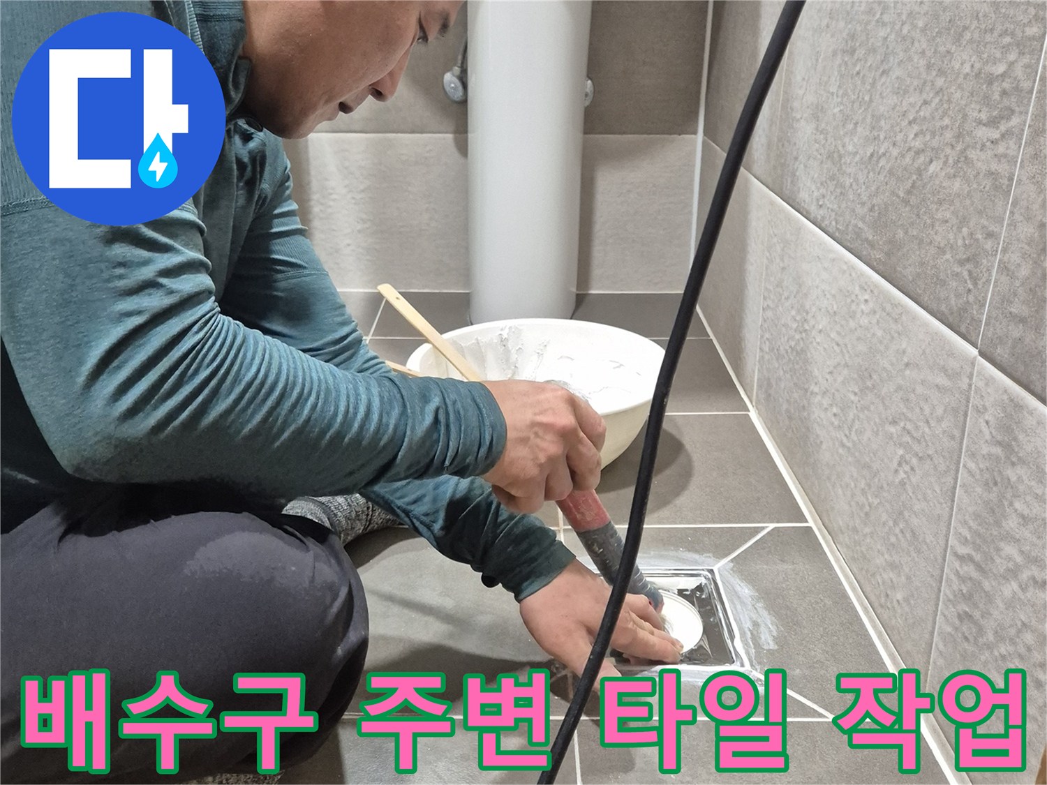 욕실 배수구 유가 주변의 탈락된 타일 틈새를 확인하며 보수 작업을 진행하는 모습입니다.