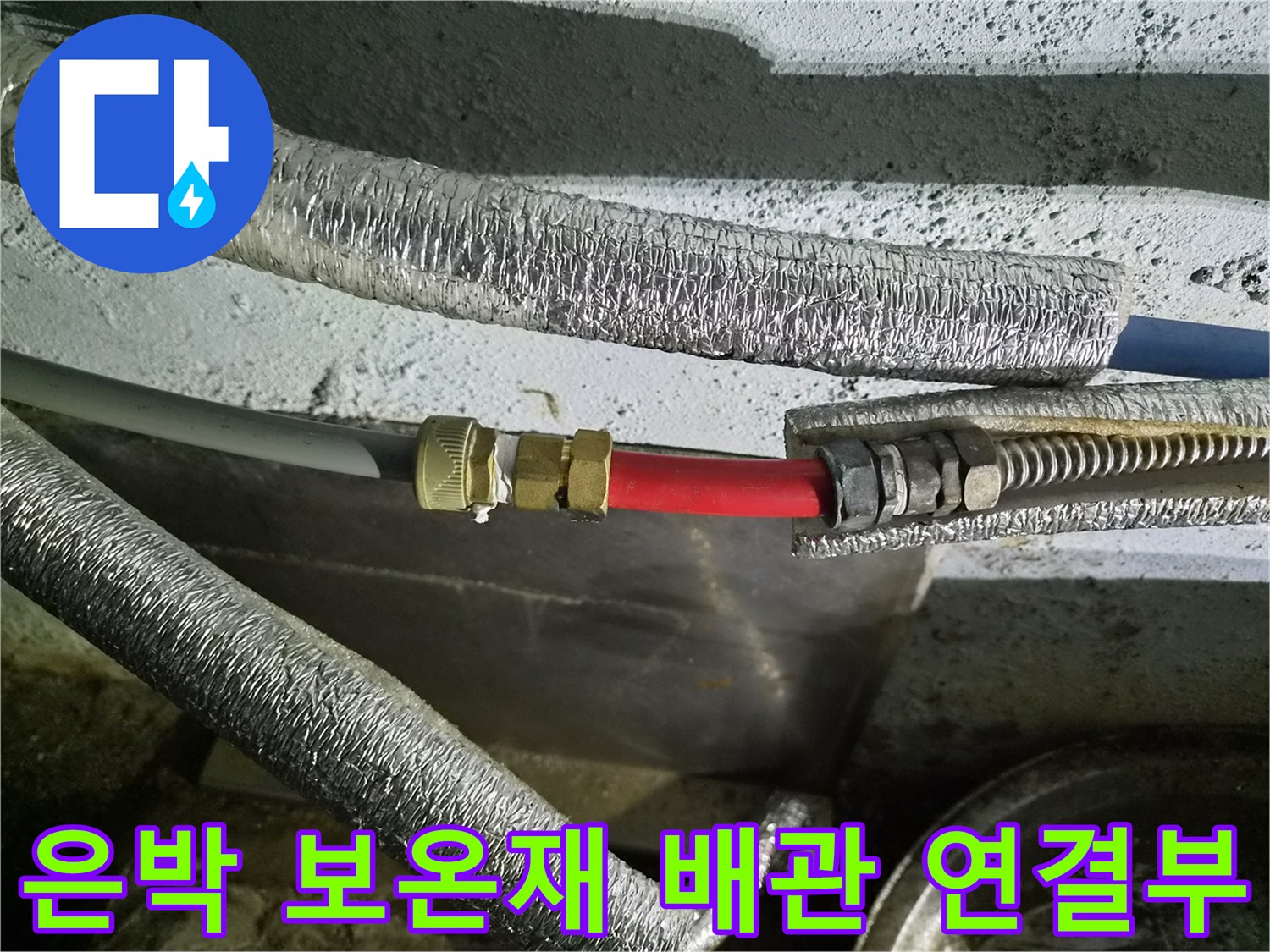 은박 보온재로 감싸진 수도 배관의 금속 연결 부위 모습