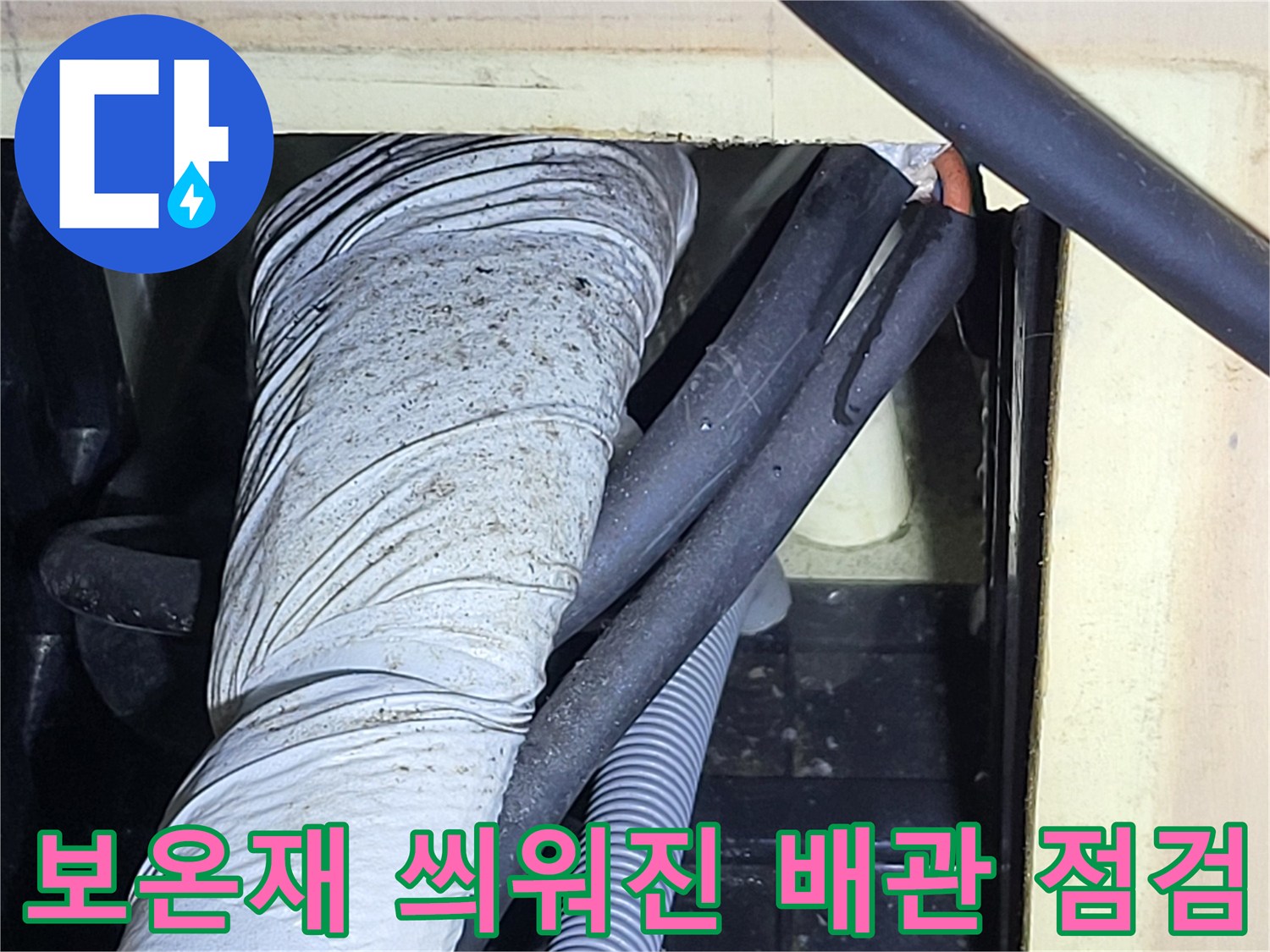 천장 내부의 하얀 보온재 배관과 회색 주름 호스 근접 촬영