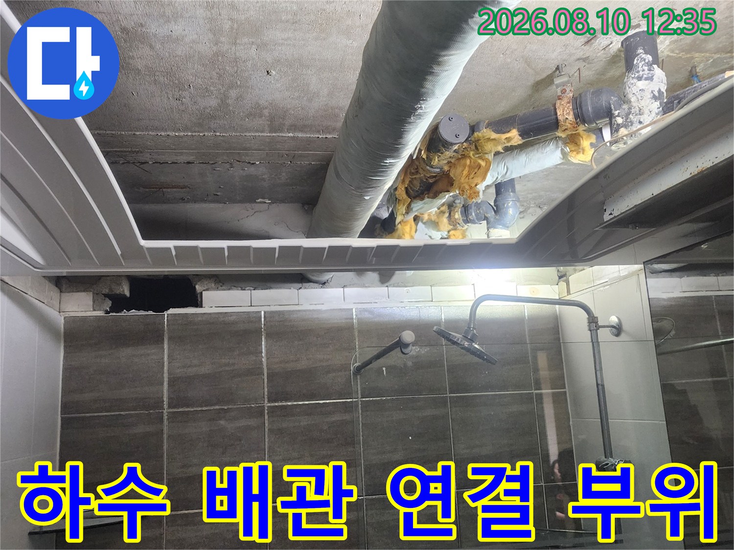 천장 내부 하수 배관의 연결 부위와 낡은 보온재를 근접 촬영한 사진입니다.