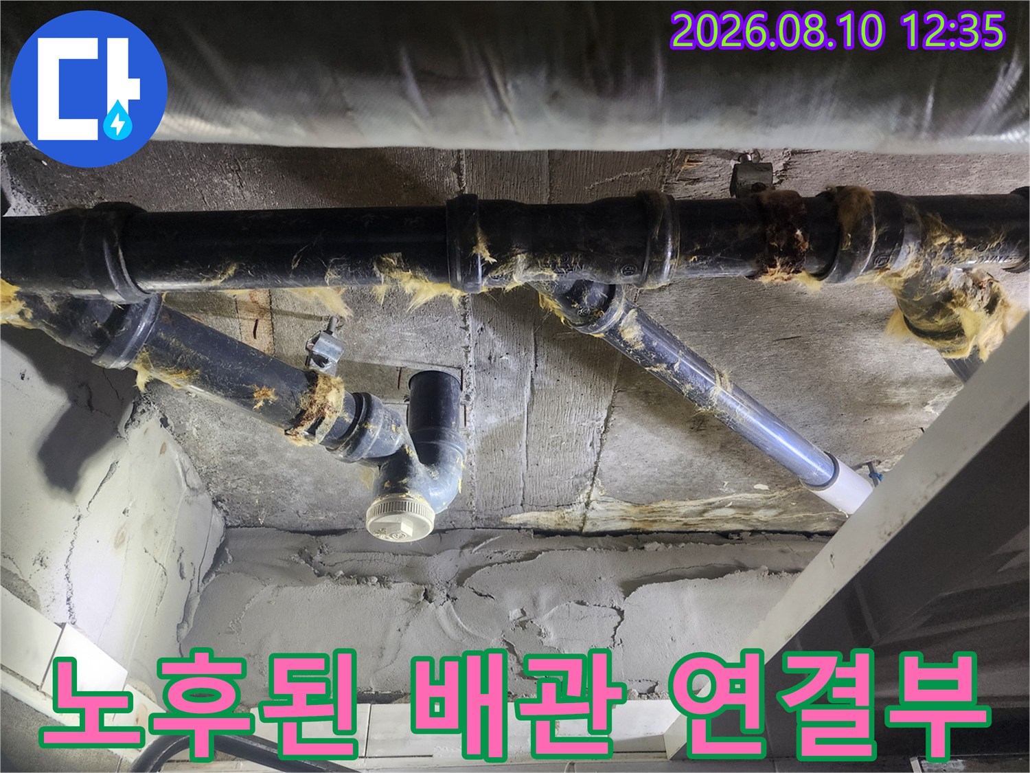 천장 내부의 낡은 하수 배관과 부식된 보온재 상태를 보여줍니다.