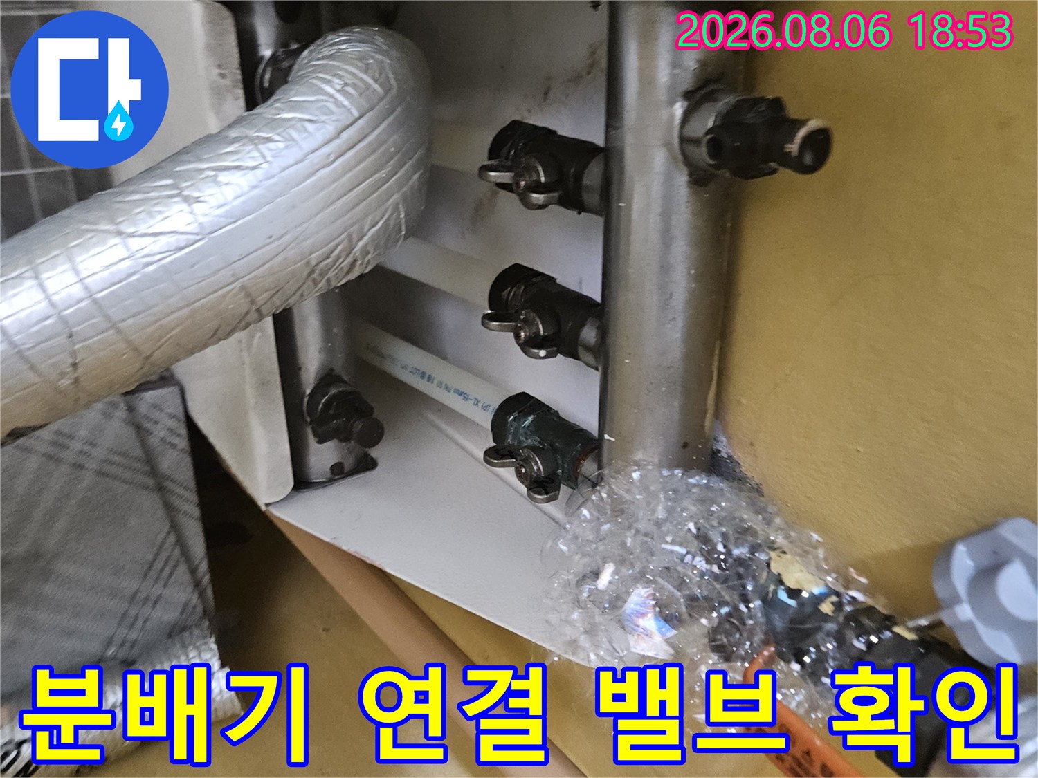 보일러 분배기 밸브들과 은박 보온재로 감싸진 상단 배관의 모습