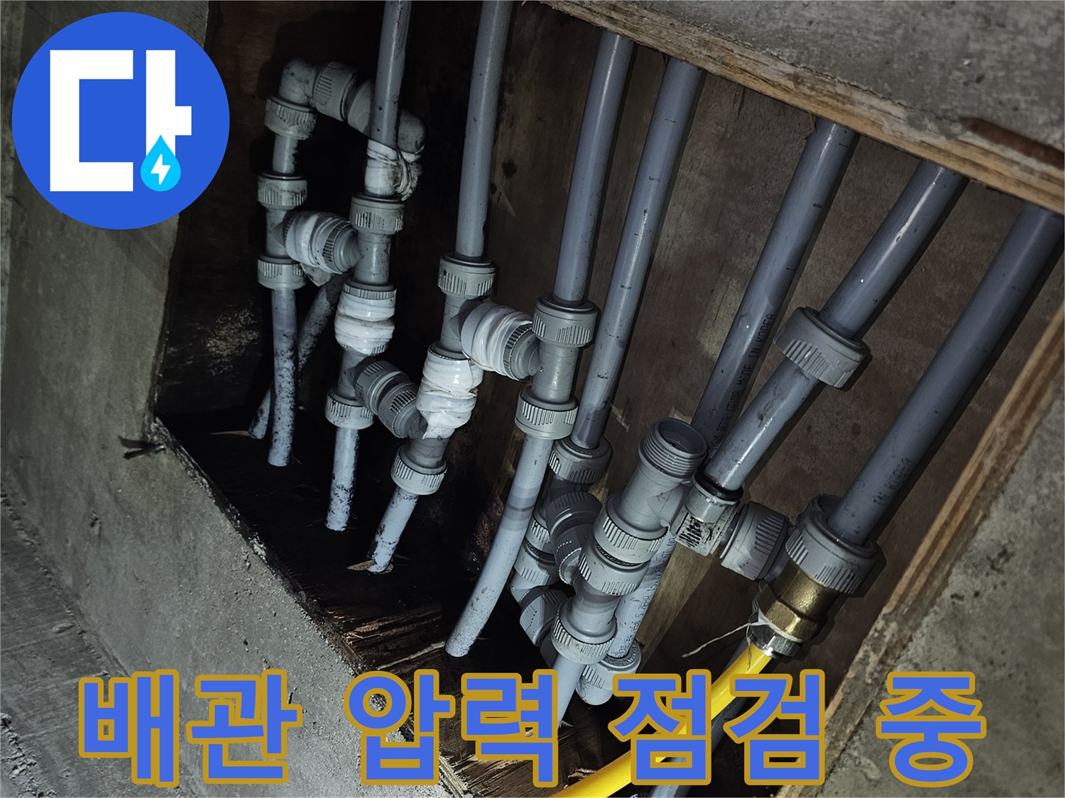 노란색 호스가 연결된-회색 수도 배관의 내부 압력 검사