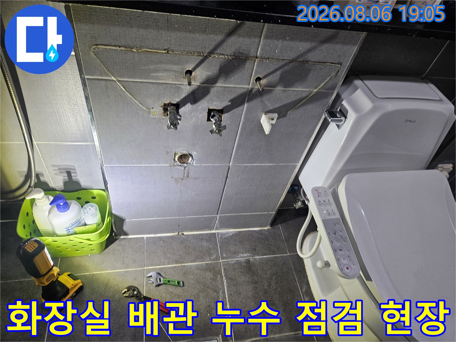화장실 벽면 배관과 세면기 주변을 점검하는 누수 탐지 장비와 공구들