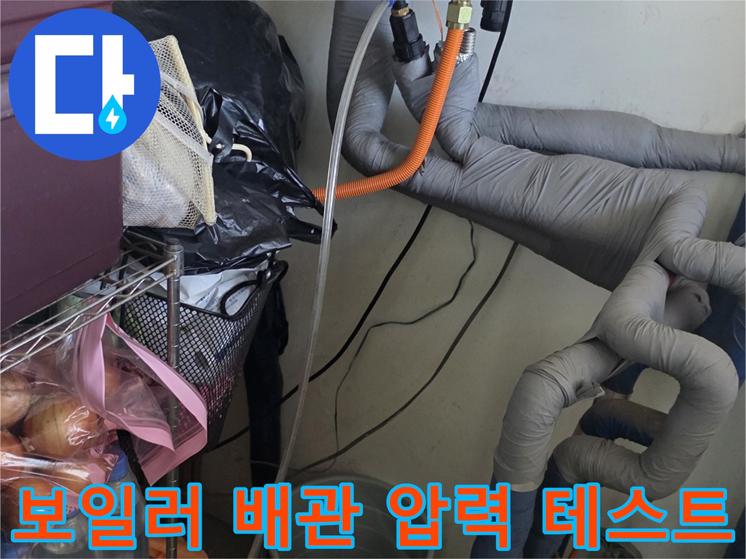 보일러 아래쪽 배관에 연결된 주황색 압력 측정 호스 - 누수 진단 과정