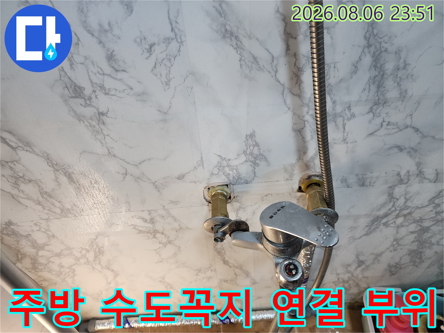 벽면에 설치된 수전과 연결된 금속 배관의 근접 촬영 이미지입니다.