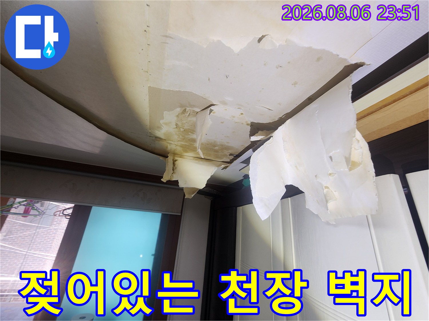 아래층 거실 천장-물에 젖어 변색되고 벗겨진 벽지 모습입니다.