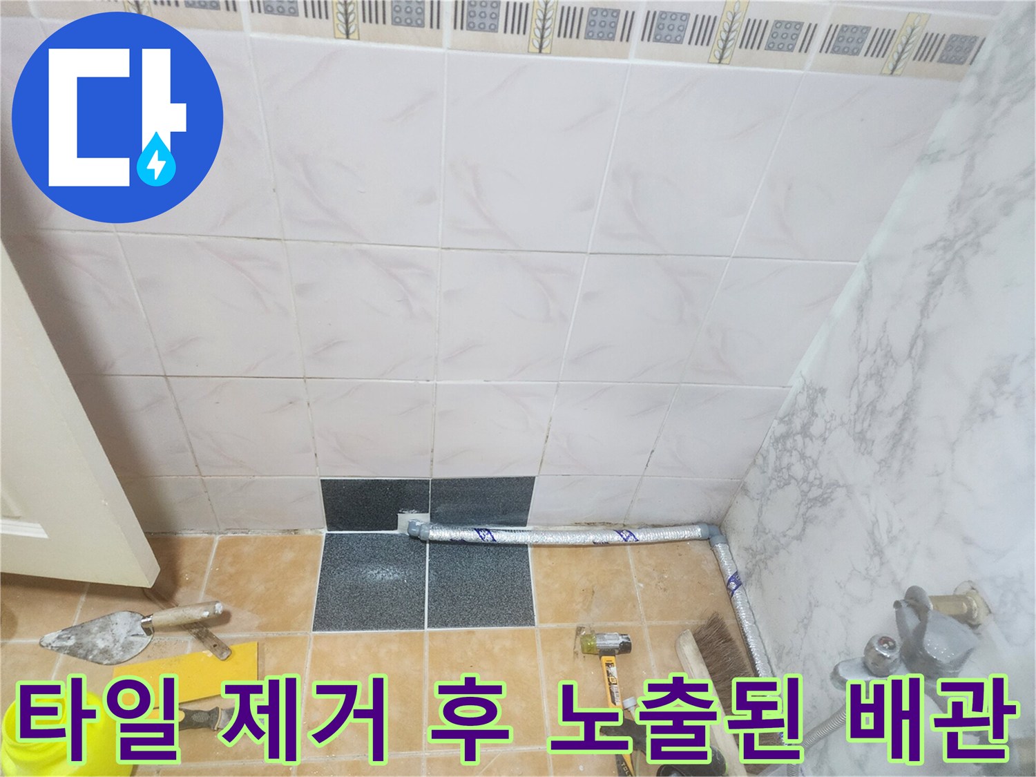 주방 타일을 걷어내고 드러난 매립 배관과 작업용 헤라