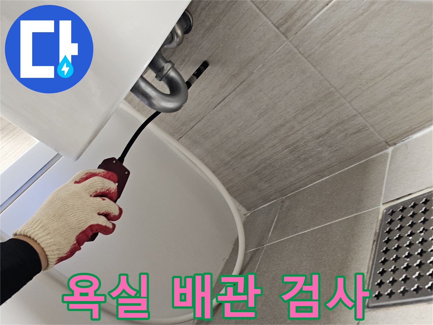 장갑을 낀 작업자가-세면대 하단 배관을 점검하는 모습