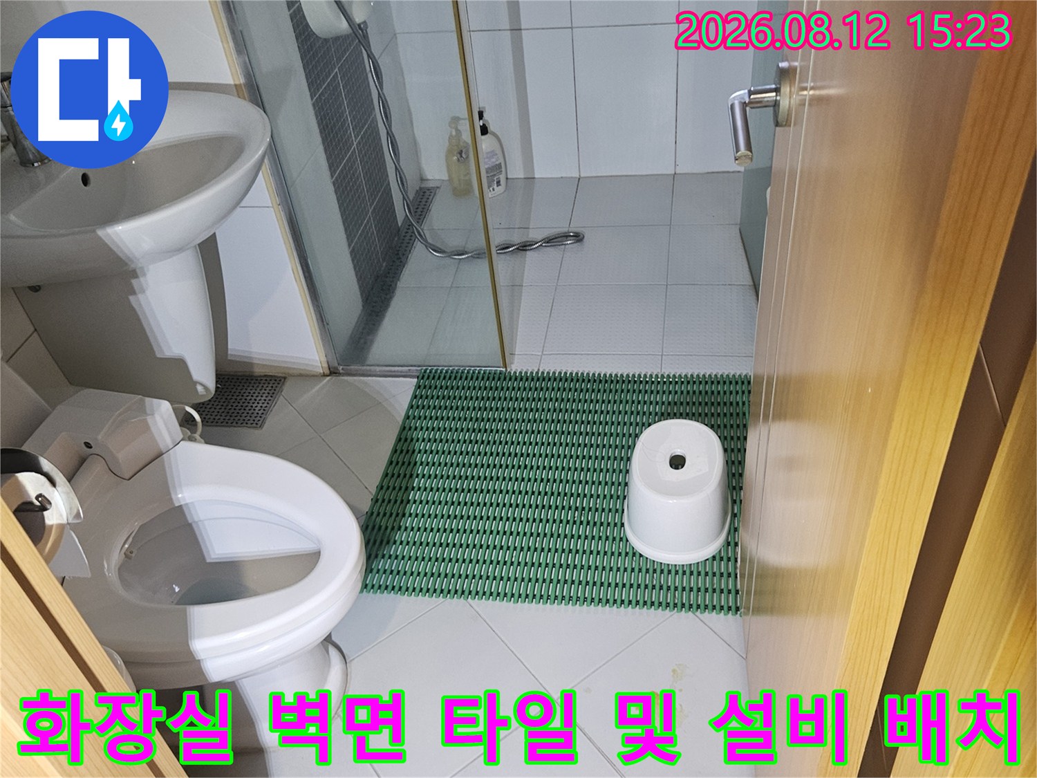 흰색과 초록색 타일이 혼합된 화장실 벽면과 설치된 위생기구 사진