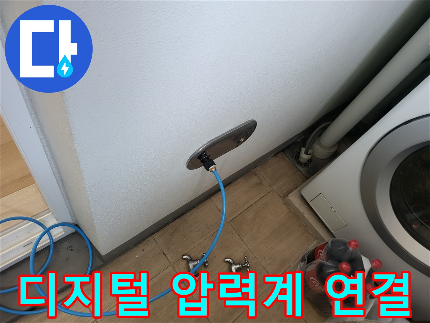 벽면 돌출된 수도 배관에 파란색 호스와 디지털 장비를 연결했습니다.
