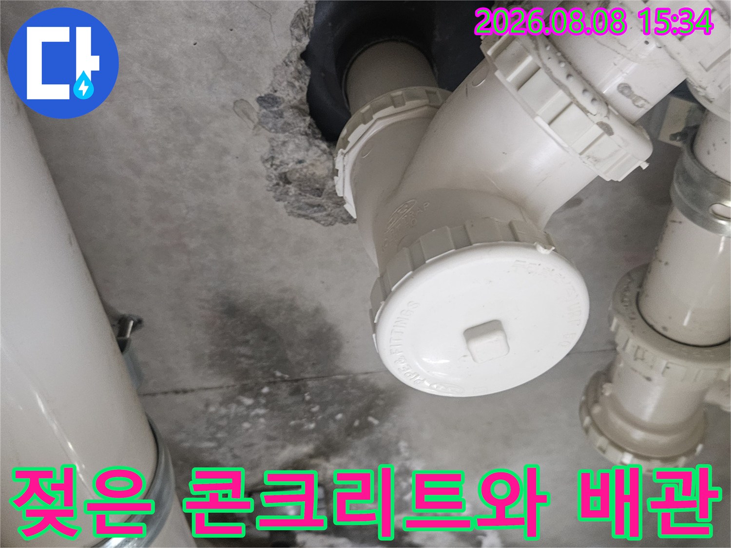 배관 연결 부위 아래쪽의 젖은 콘크리트 면과 배관 구조물 사진입니다.