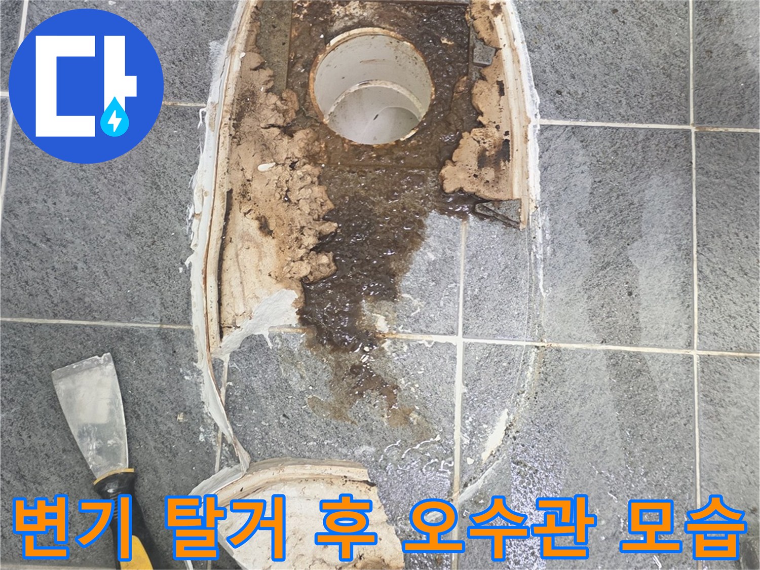 탈거된 양변기 자리의 배수관과 오염된 타일 바닥을 촬영하였습니다.