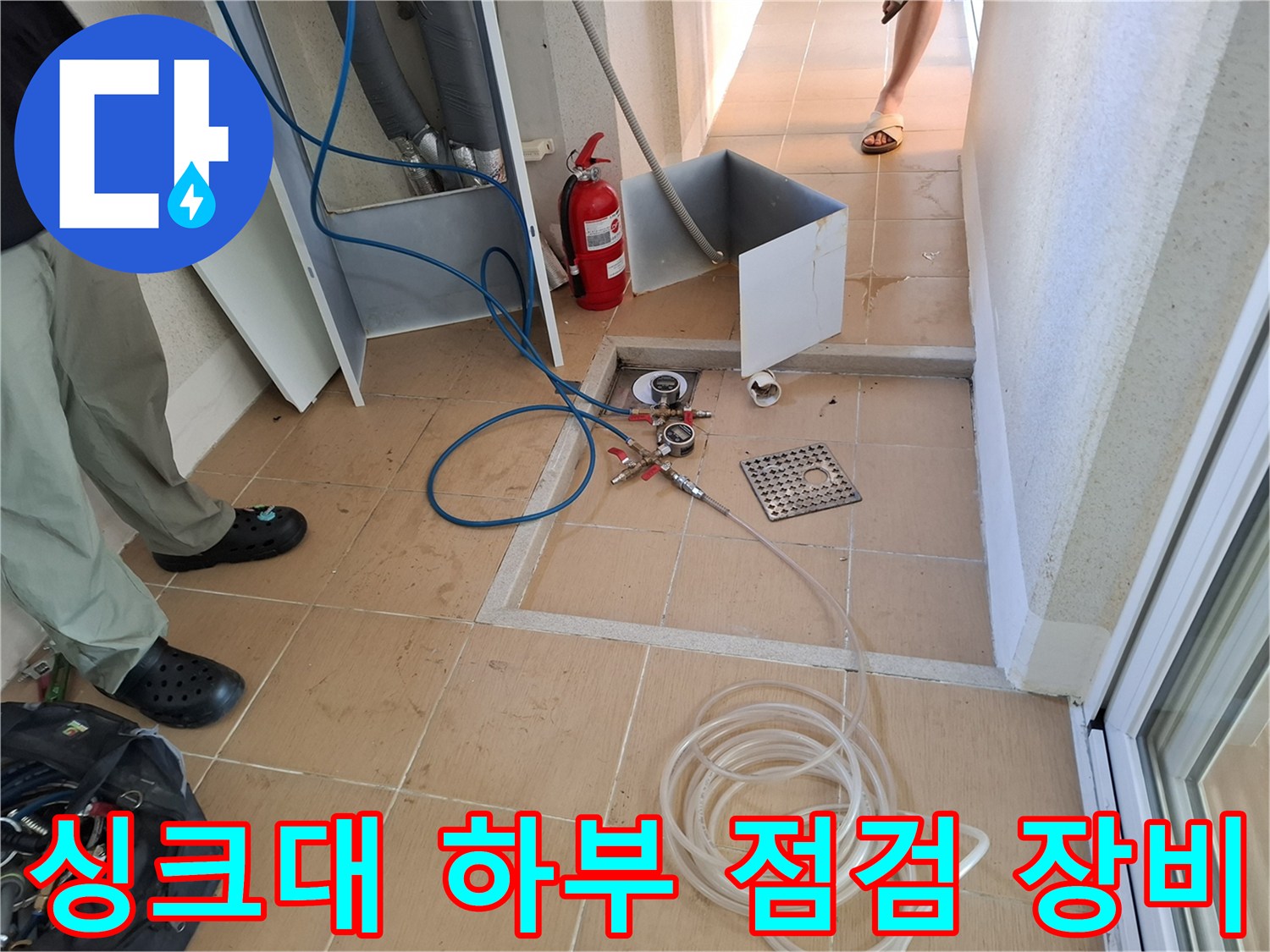 싱크대 밑바닥 배관 연결부에 설치된 공압 테스트용 호스와 게이지