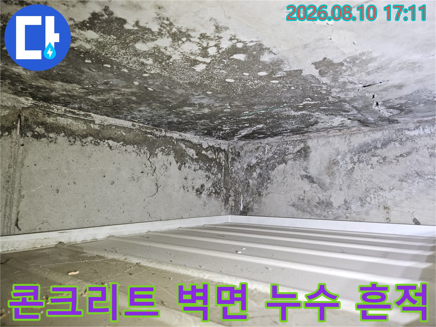 습기로 인해 부식된 콘크리트 벽면과 천장 접합부의 누수 자국
