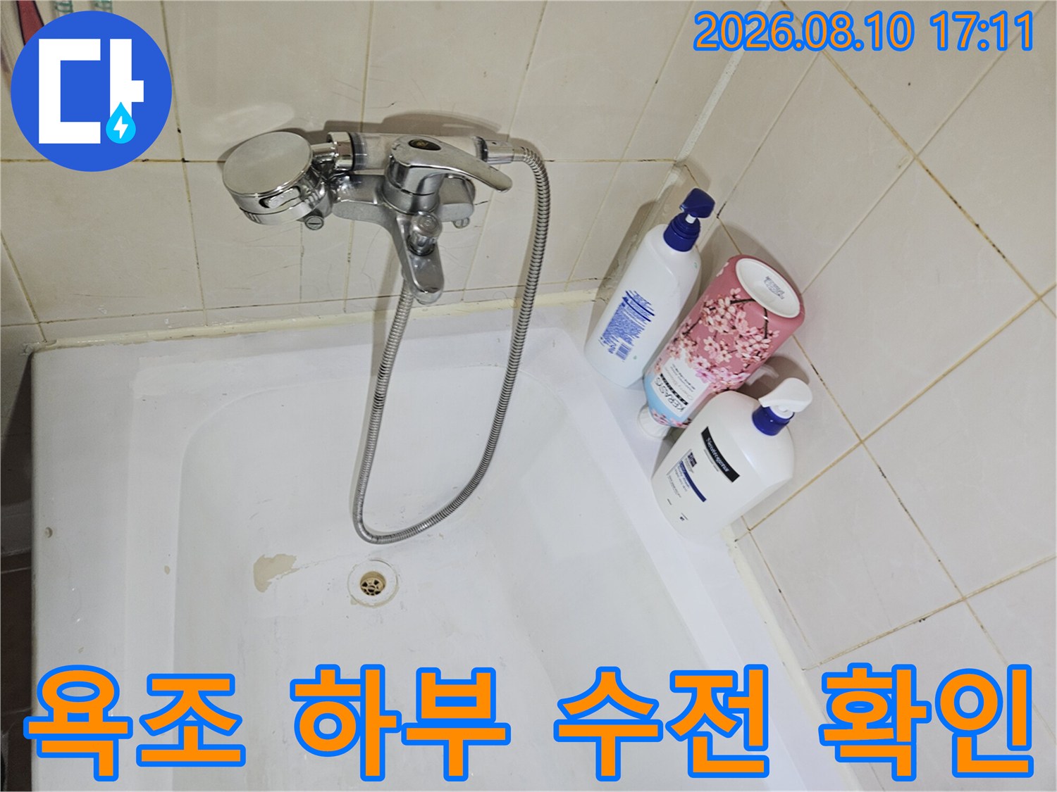 욕조 옆 벽면 타일과 샤워기 수전의 상태를 보여줍니다.