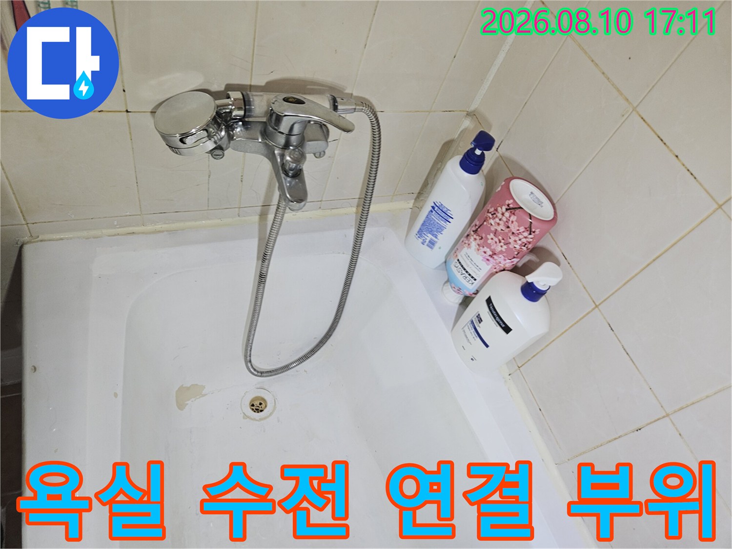 화장실 욕조에 설치된 은색 수전과 샤워 호스 모습입니다.