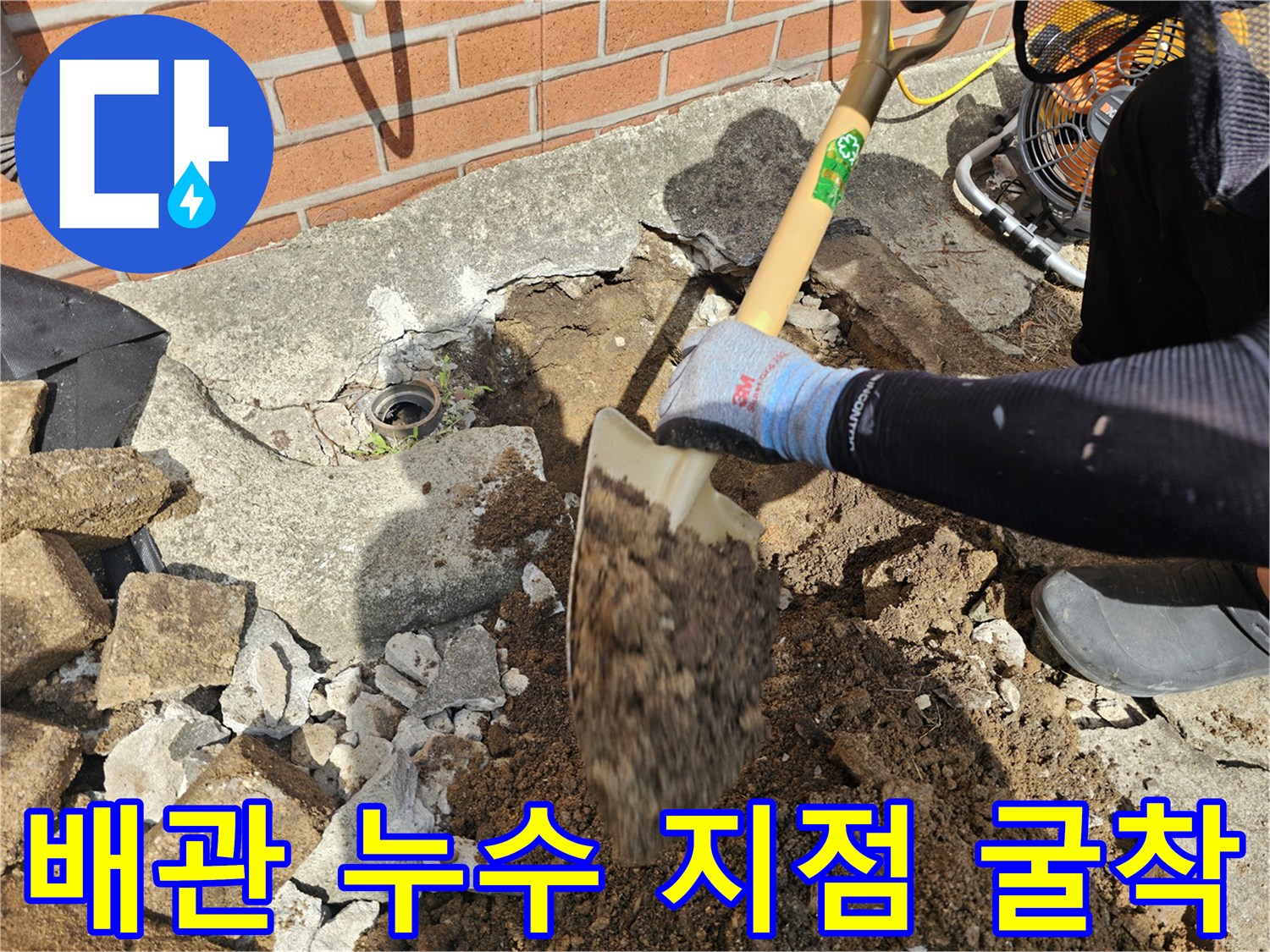 마당 콘크리트 바닥-배관 파손 부위를 찾기 위해 삽으로 땅을 파는 모습
