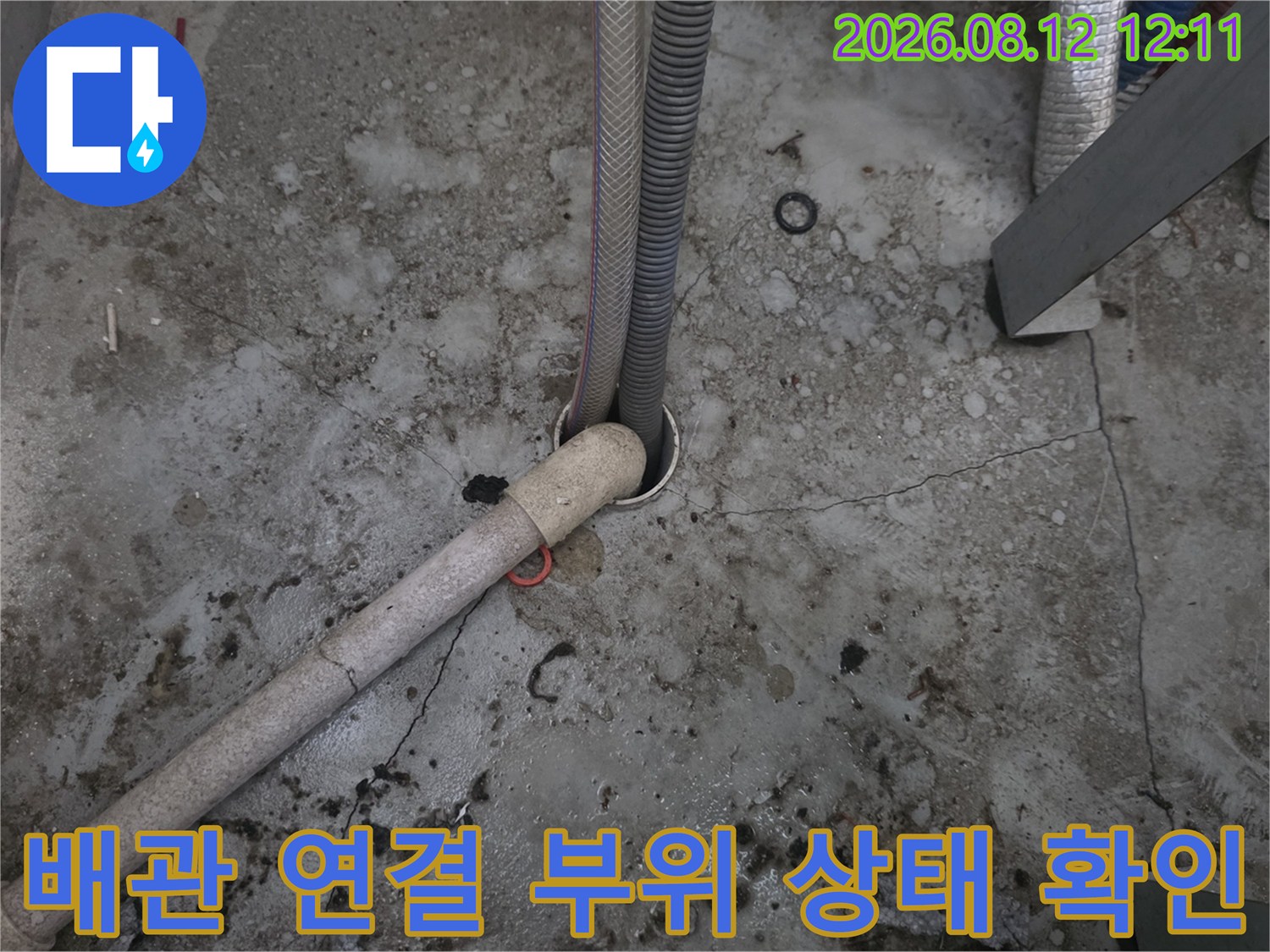 배관 연결부-노출된 배관의 연결 지점과 주변 바닥의 습기 여부를 점검하고 있습니다.