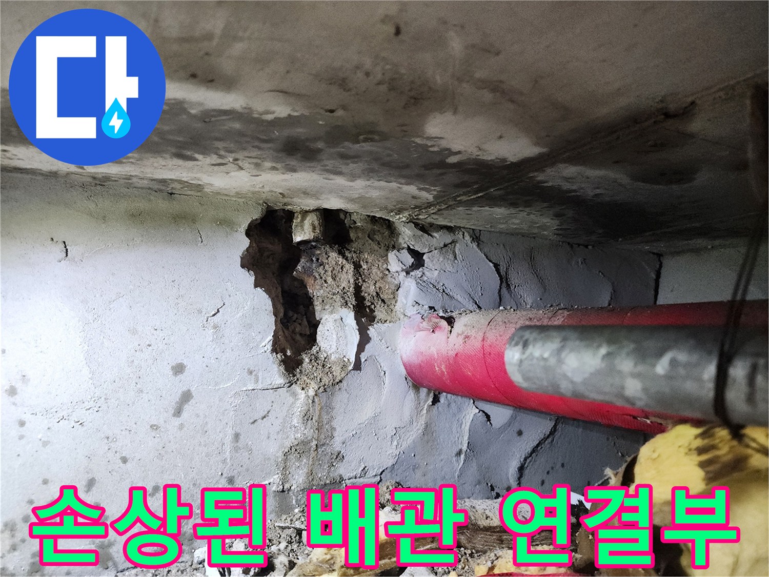배관 수리 현장-붉은색 배관과 균열된 벽체 부위