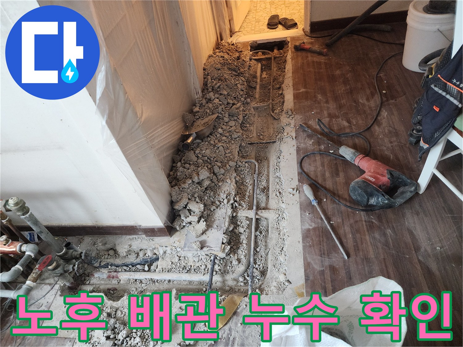 파헤쳐진 콘크리트 층 사이로 보이는 물에 젖은 배관 부위